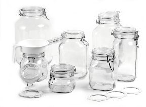 Acht leere Einmachgläser aus Glas in verschiedenen Größen mit Bügelverschluss, dazu ein Trichter und mehrere Dichtungsringe