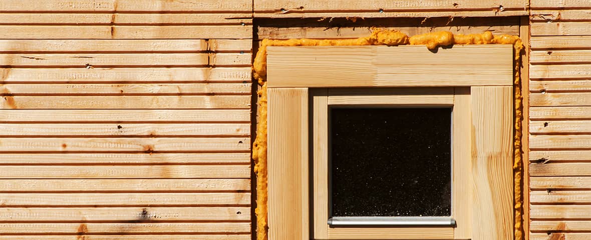 Fenster in einer Holzfassade, die Fuge rundherum ist mit Montageschaum abgedichtet