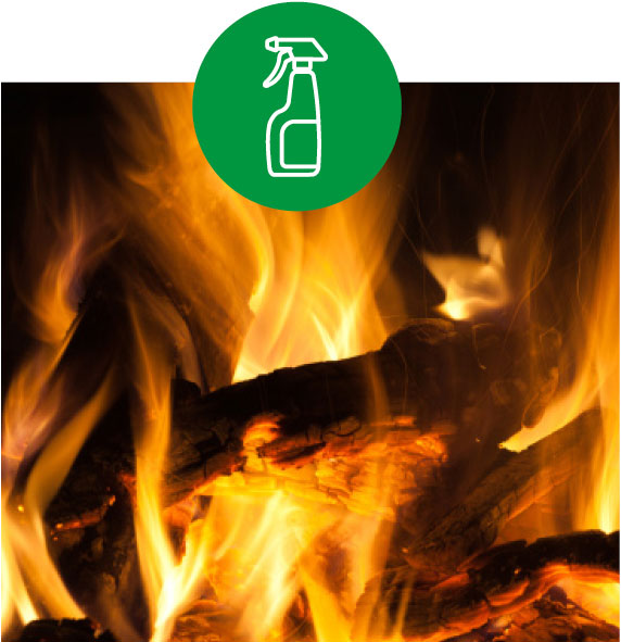 Nahaufnahme von brennendem Kaminholz mit Flammen, darüber ein grünes Symbol mit Reinigungsspray.