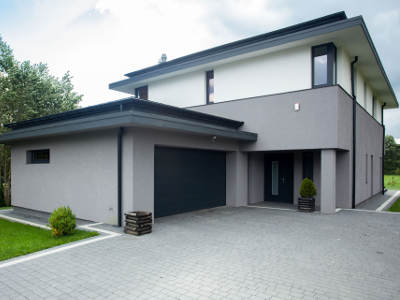Alt-Tag: Modernes Einfamilienhaus mit Garage – Blick von außen auf das Wohngebäude.