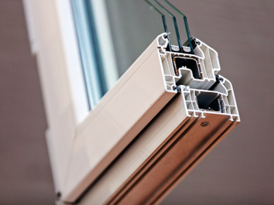 Foto eines aufgeschnittenen Kunststofffensterprofils mit Dreifachverglasung, zu erkennen sind die Hohlkammern im Rahmen sowie die einzelnen Scheiben mit Abstandshaltern