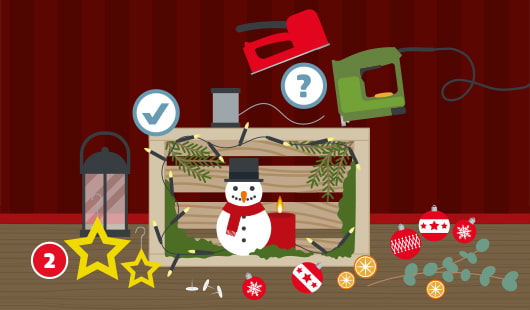 Eine schematische Darstellung zeigt eine selbst gestaltete weihnachtliche Dekobox aus Holz mit einem Schneemann, Kerze, Zweigen und einer Lichterkette. An der linken oberen Ecke ist ein Häckchensymbol. Darum herum liegen Dekoelemente wie Christbaumkugeln, Orangenscheiben, Sterne und eine Laterne. Zwei Tackergeräte, dazwischen ein Fragezeichensymbol, liegen bereit. Unten links ist ein roter Kreis mit einer weißen 2