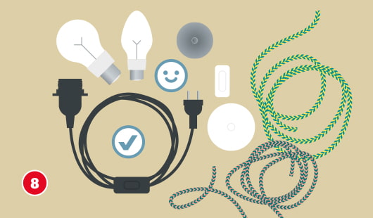 Eine schematische Darstellung zeigt verschiedene Komponenten zur Montage einer Lampenfassung. Abgebildet sind zwei Glühbirnen, eine Fassung mit Kabel und Schalter, ein Stecker, Deckenhalterungen sowie dekorative Textilkabel in verschiedenen Farben. Ein Häkchensymbol kennzeichnet das korrekte Anschlusskabel. Zwei Smileys weisen auf geeignete Kombinationen hin. Unten links ist ein roter Kreis mit einer weißen 8