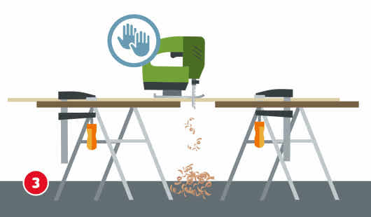 Eine schematische Darstellung zeigt den Einsatz einer grünen Stichsäge, die ein auf zwei Böcken fixiertes Holzbrett durchtrennt. Holzspäne fallen während des Sägevorgangs zu Boden. Ein Symbol mit zwei Händen oberhalb der Maschine weist auf die korrekte Handhaltung hin. Unten links ist ein roter Kreis mit einer weißen 3