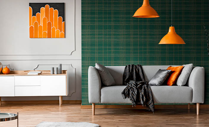 Wohnzimmer mit Hauptfarbe Grün an der Wand und Accessoires in Komplementärfarbe Orange