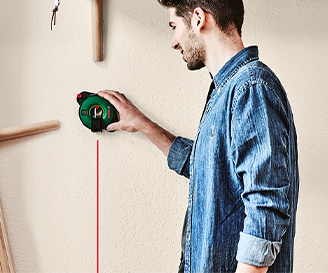 Ein Mannverwendet Messtechnik von Bosch an einer Wand