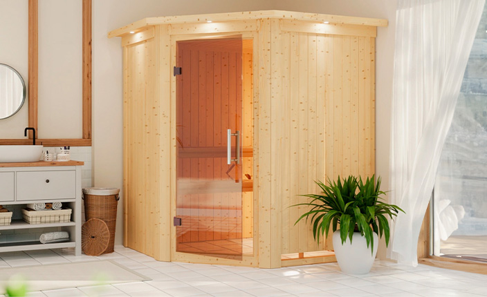 Moderne Ecksauna aus hellem Holz in einem lichtdurchfluteten Raum mit Fensterfront, dekorativer Zimmerpflanze und stilvollem Waschtisch.