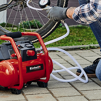Jemand pumpt ein Fahrrad Reifen auf mit einem Einhell Kompressor