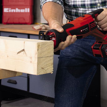 Jemand schneidet Holz mit einer Einhell Säge