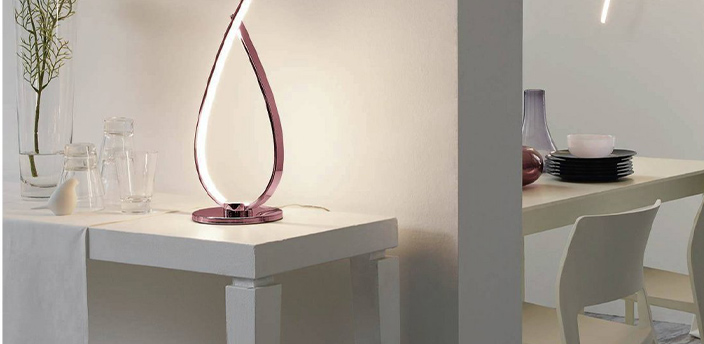 Elegante LED-Leuchte in moderner Tropfenform auf einem weißen Tisch.