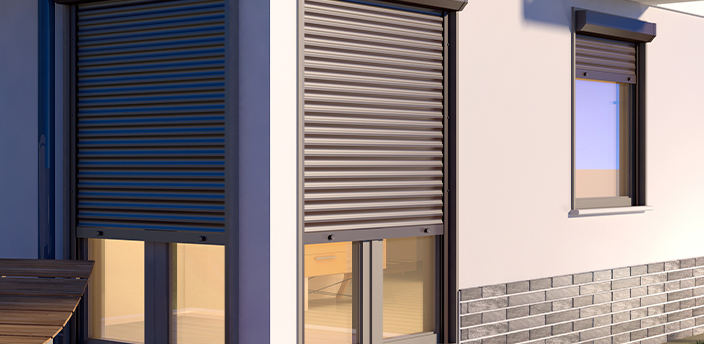 Geschlossene Rollläden an Fenstern eines Hauses in der Abenddämmerung.