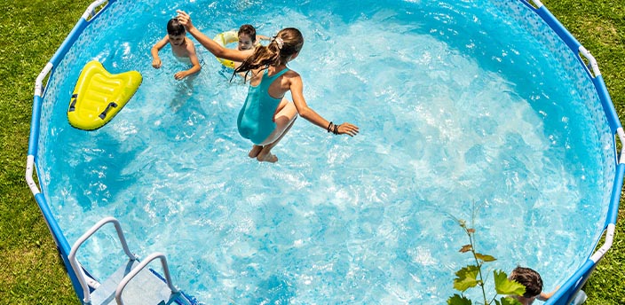 Kinder die in einem Pool im Garten plantschen