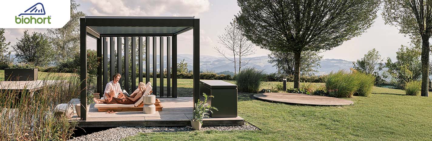 Ein Pergola steht in einem Garten mit zwei Personen im Bild