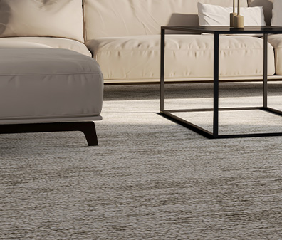 Modernes Wohnzimmer mit beigem Teppichboden, hellem Sofa, schwarzem Metall-Couchtisch und Design-Sessel vor großen Fenstern.