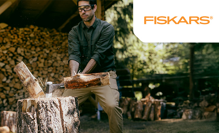 Ein Mann spaltet ein Holtstück mit einer Fiskars Axt