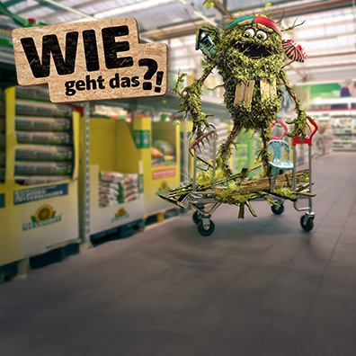 Ein Gartenmonsterchen auf einem Einkaufswagen in einem Baumarkt